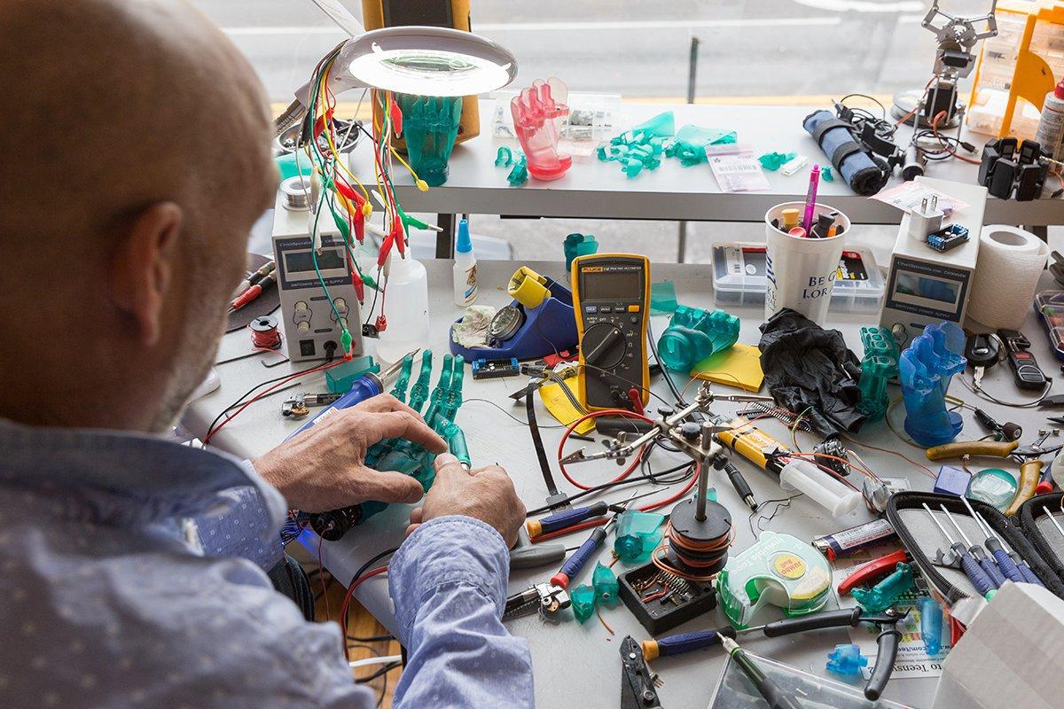 An engineer assembling 3D printed robotic prosthetic hands.