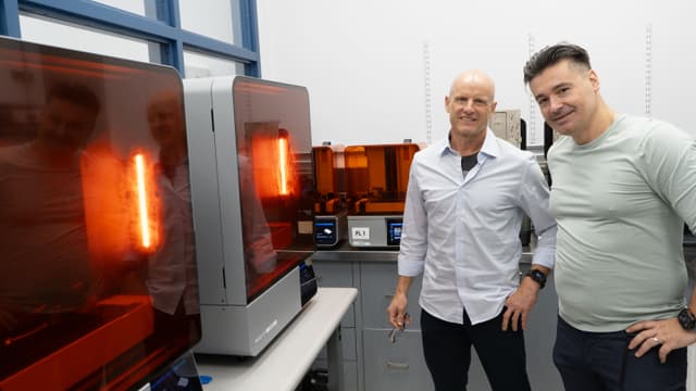 Two men in a lab in front of Form 4B and Form 4BL 3D printers
