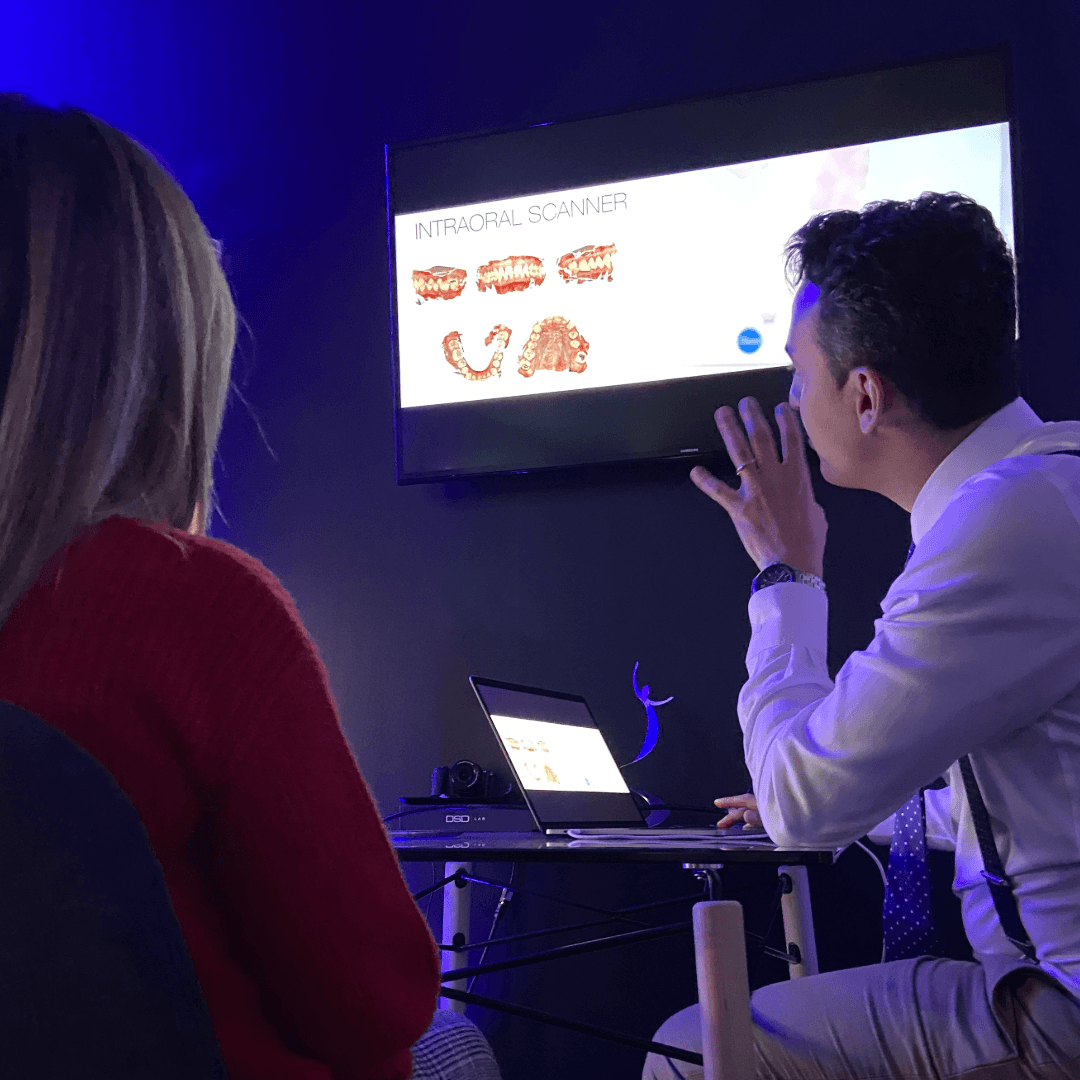 Two people talking in front of a screen