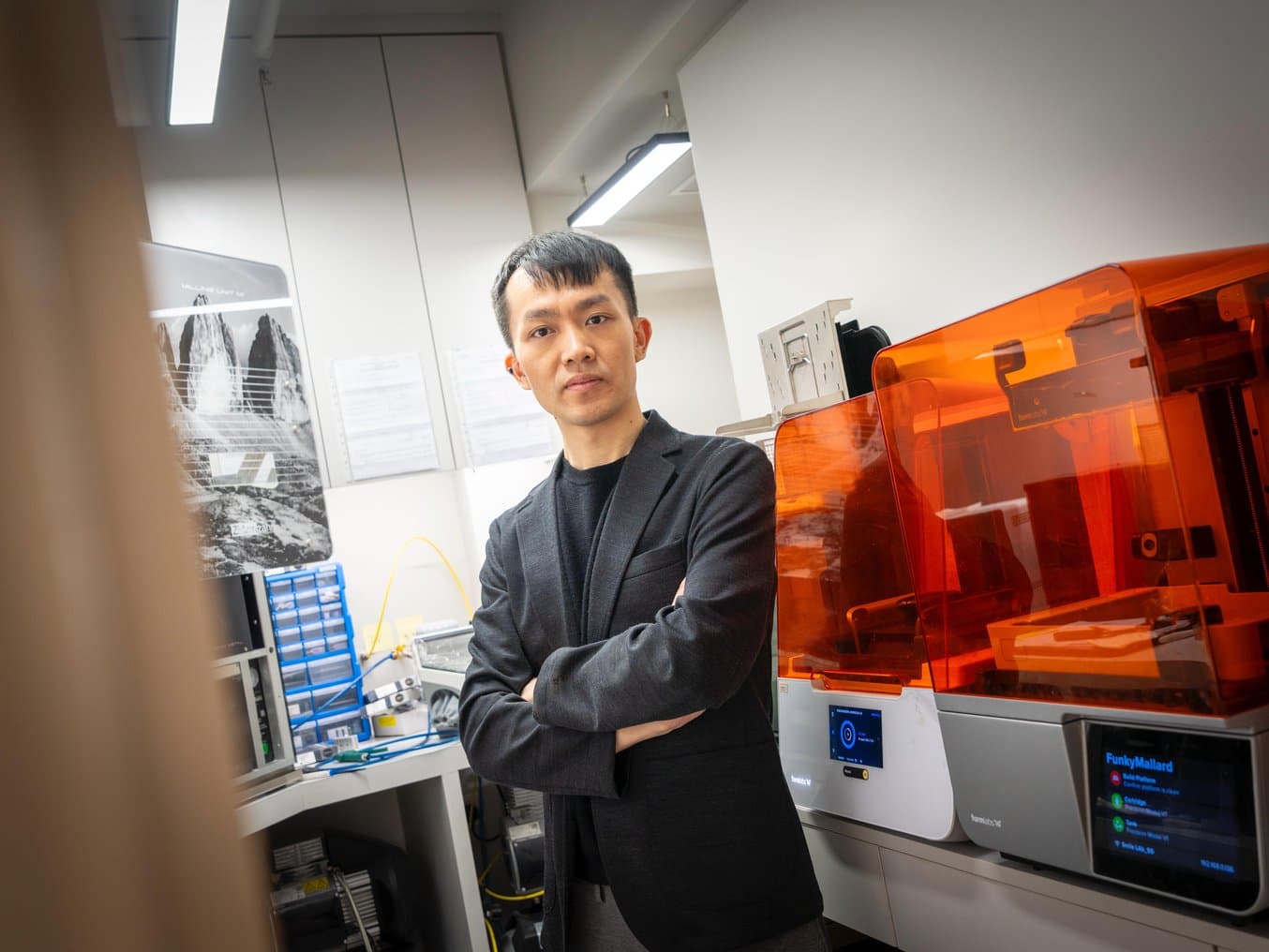 Person wearing black with arms crossed standing in front of Form 4B and Form 3B 3D printers