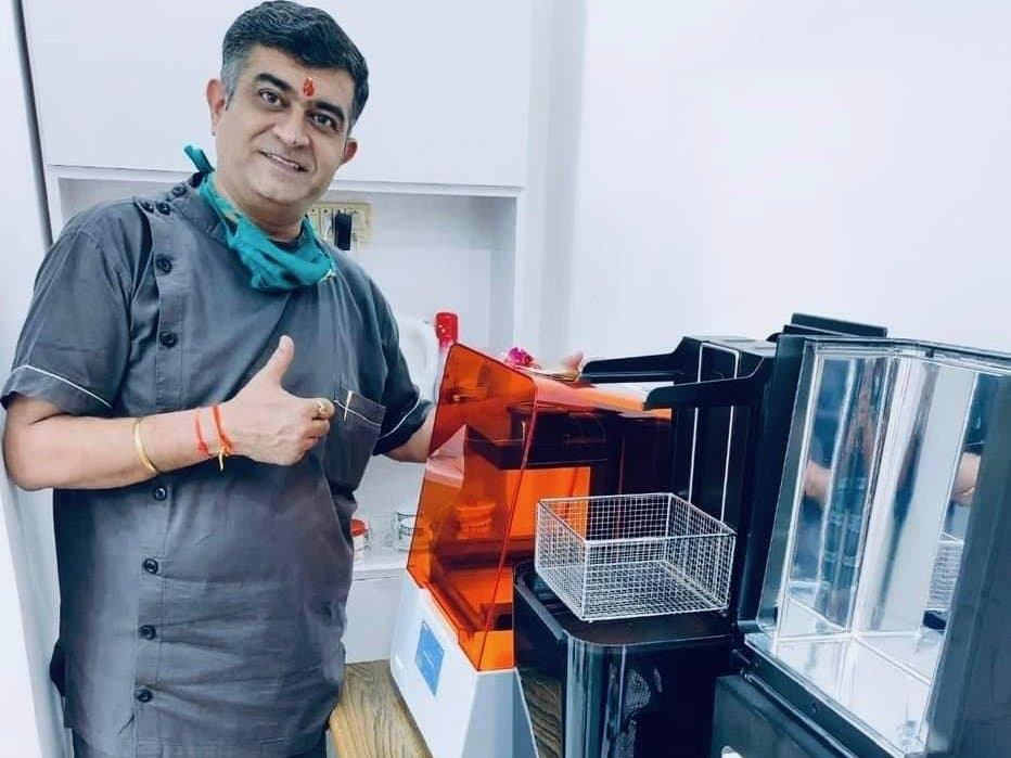 Dr. Puneet Kalra stands in front of the Form 3B+ printer giving the thumbs up sign