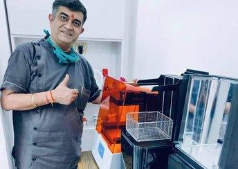 Dr. Puneet Kalra stands in front of the Form 3B+ printer giving a thumbs up