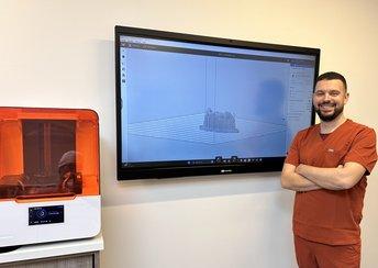 Dr. Édouard Lanoiselée and a Form 3B+ 3D printer in front of a screen showing a digital model of teeth to print