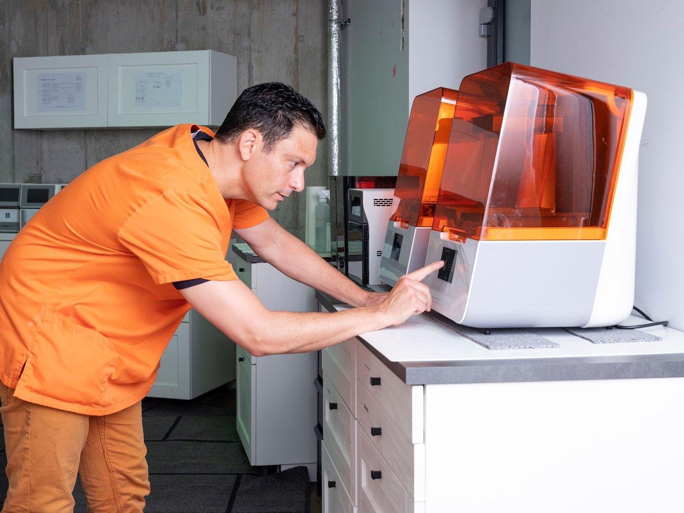 Dental Technician initiating printing on the Form 3B+ 3D printer